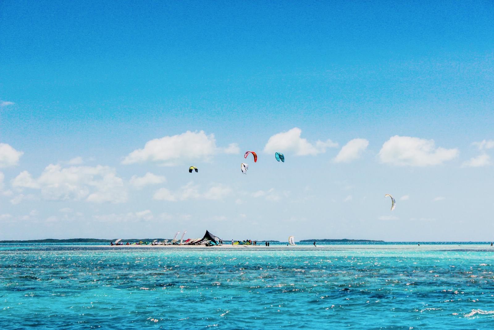Vibrant kite surfing scene in Los Roques, Venezuela, showcasing azure waters and clear skies.